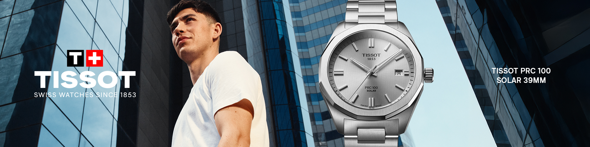 Advertisement for Tissot watches featuring a young man in a white t-shirt standing in front of modern glass skyscrapers. To the right, a close-up of the Tissot PRC 100 Solar 39mm watch is displayed prominently. The watch has a silver metal band and a sleek silver dial with the date shown at the 3 o'clock position. Text on the image includes the Tissot logo with the Swiss flag, the slogan 